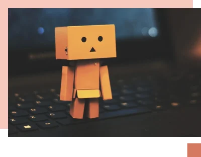 Computer pixel character in yellow with surprised face standing on laptop keyboard